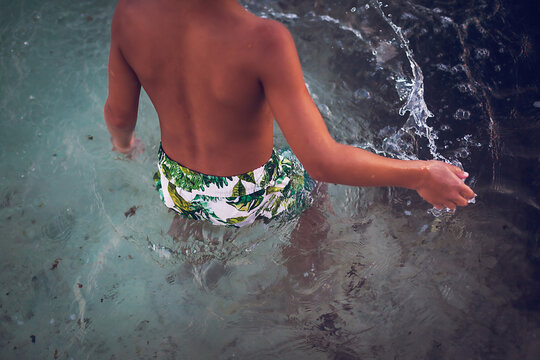 Close up of young boy splashing the water