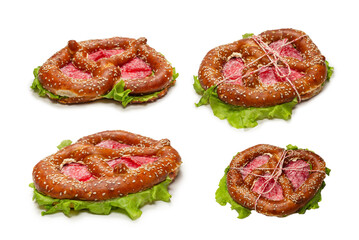 Pretzel with salami and lettuce isolated on a white background.