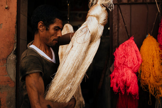 Artisan hanging silk thread to dry in workshop.