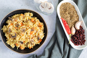 Vegetarian pilaf with mushrooms on a light background with gray textiles.