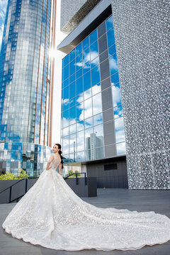 Bride In A White Dress In The Modern City Of Glass And Metal Between The Reflection Of The Sky