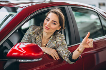 Woman sitting i car in a car showrrom