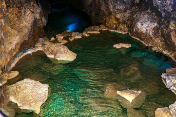 Stalactite, stalagmite on the walls of the cave. Cave lake. Template for design.
