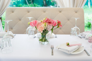Flower table decorations for holidays and wedding dinner. Table set for holiday, event, party or wedding reception in outdoor restaurant.
