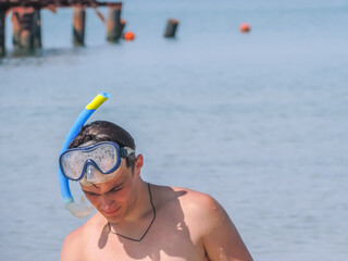 A young man with a mask and snorkel for diving under water. Diving underwater with a mask and...