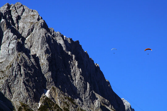 Paragleiter &uuml;ber schneebedeckten Gipfel