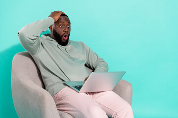 Portrait of handsome trendy amazed guy using laptop news reaction isolated over vivid teal...
