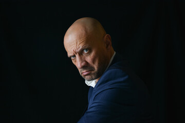 Portrait of a strong manly man on a black background. A strong-willed male look. A handsome...