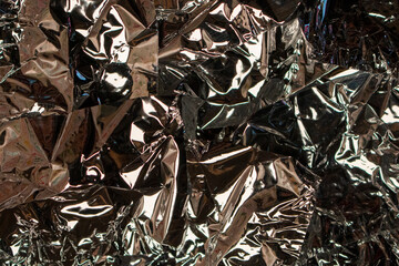 crinkled foil sheet candy wrapper dark shiny aluminum silver tin backdrop
