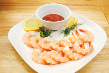 Appetizer of Fresh Cooked Shrimp with Sliced Lemon, cocktail Sauce, Dill, and Parsley