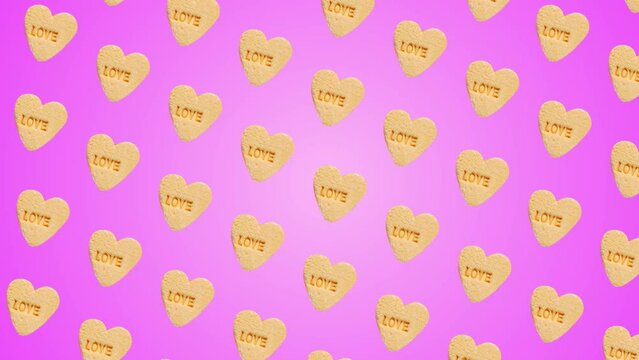Professional motion design 4K animated pattern with heart-shaped yellow candies with label "Love" Moving Diagonally on different sides on trending pink color gradient backgroundnd, top view. 3 in 1 di