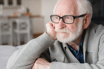 Closeup cropped portrait of lonely missing old people, senior man elderly grandfather sitting on the sofa, feeling pain, sick, ill, nostalgy, fraud, bankruptcy at home alone, needing help.