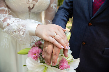 A pair of gold rings for wedding ceremony on bride and groom hands
