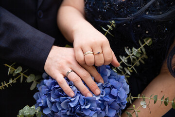 Fototapeta premium A pair of gold rings for wedding ceremony on bride and groom hands