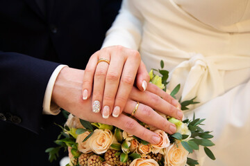 A pair of gold rings for wedding ceremony on bride and groom hands