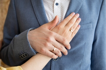 A pair of gold rings for wedding ceremony on bride and groom hands