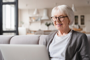 Closeup cropped photo of active caucasian old elderly senior woman grandmother using laptop online,...