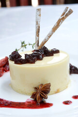 panna cotta dessert with pieces of sherry jelly strawberry jam garnished with cinnamon sticks and star anise