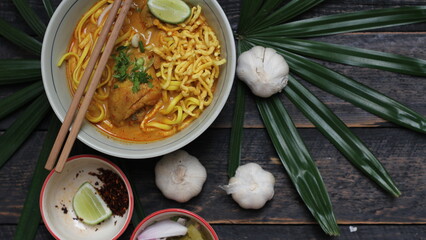 Fototapeta na wymiar Khao Soi Recipe,Khao Soi,Khao Soi Kai, Thai Noodles Khao Soi, Chicken Curry with seasoning served on wooden table