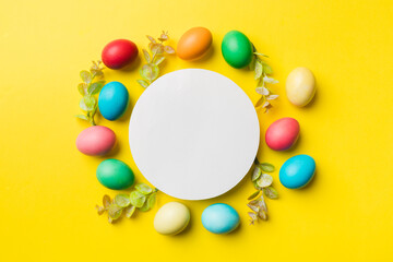 round frame multicolored Easter eggs with white blank paper on a brown background, close-up, space for text, blank for design, selective focus, tinted image