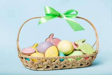 Colorful easter cookies in basket with Multi colors Easter eggs on colored background . Pastel color Easter eggs. holiday concept with copy space