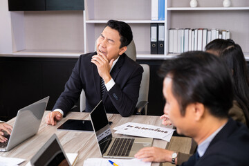 Selective focus at face of the boss who sit inside of meeting room yawning and feel sleepy. Boring workplace, lazy worker concept.