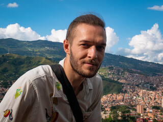 Naklejka na ściany i meble White Man without Mask is Posing with the Background of the City of Medellin, Colombia