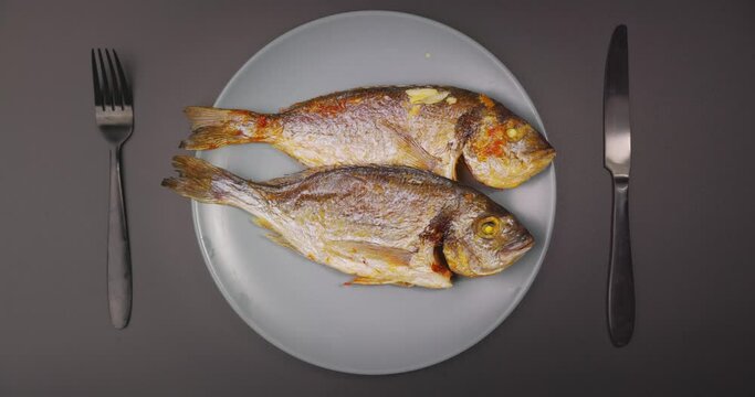 Closeup footage of serving whole grilled salt water fish