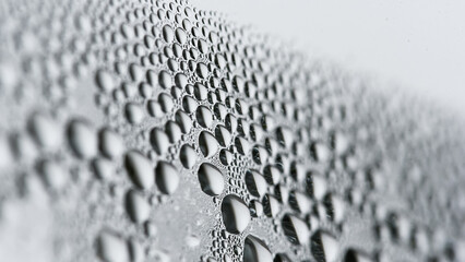 Texture with drops of water. Macro view in neutral tones of a lot of water drops on a window, great texture and background.