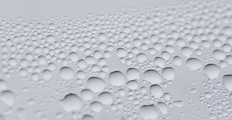 Texture with drops of water. Macro view in neutral tones of a lot of water drops on a window, great texture and background.