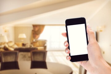 Human using smartphone, controlling smart home systems in modern apartment, blank screen