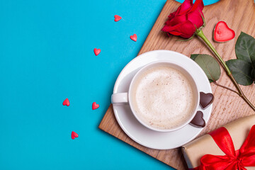 Valentine's Day breakfast in bed. Gift, coffee rose, candles, hearts on blue background. Valentines day concept.