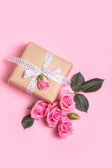 Craft gift box on pink background with pink roses . Valentine's Day. Mother's Day. Flat lay, top view