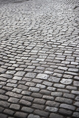 Old stone paved road made of smooth paving stones polished by time - roadway and pavement
