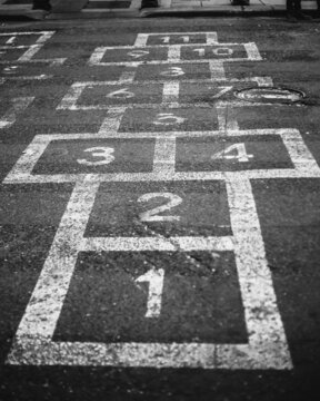 Cages with numbers on the pavement for jumping - children play hopscotch on the road