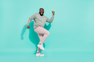 Fototapeta na wymiar Full length body size view of cheery lucky attractive guy dancing rejoicing having fun isolated over bright teal turquoise color background