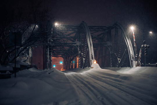 night photo of a snow-covered bridge during a blizzard