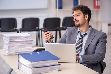 Young businessman employee and too much work in the office