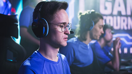 Esportsman gamer in glasses putting on headphones at start of professional gaming tournament © Framestock