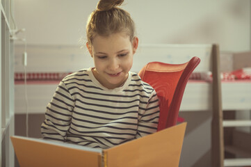 Teen girl reading text in notebook at home