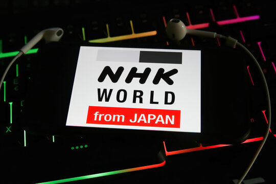 Viersen, Germany - January 9. 2022: Closeup of mobile phone with logo of japan radio station nhk world on computer keyboard