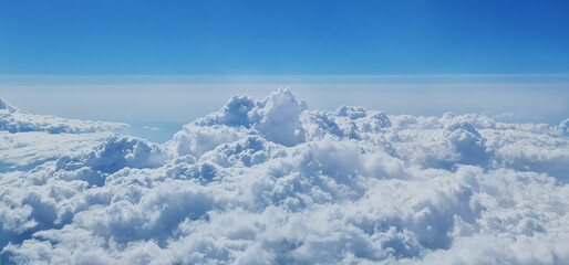 Fototapeta premium Beautiful sky above the clouds. View of blue sky and clouds from plane window.
