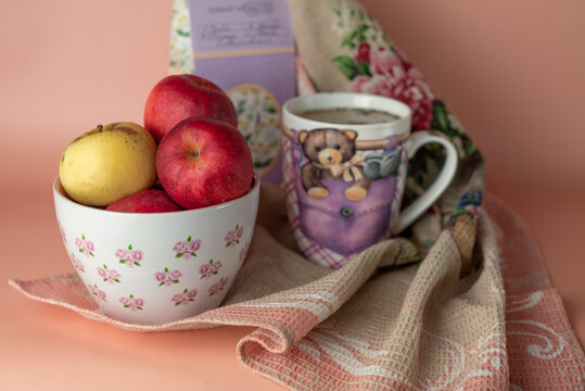 a cup with the image of a bear and a mouse with a lilac tea package with apples in a plate and a towel.
text translation: herbal tea, thyme, St. John's wort, chamomile, lavender juniper 