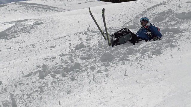 Unrecognizable Freestyle skier falling off-piste on fresh powder snow
