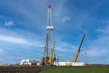 oil drilling rig and cranes on field petrochemical industry