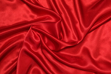 Fototapeta na wymiar Texture of crumpled red satin fabric, beautiful pattern, top view.