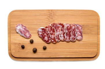Smoked sausage cut on a wooden board with peppers isolated on white background