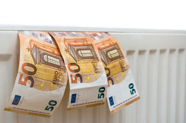 Concept. Expensive heating. Money on the radiator isolated on white background