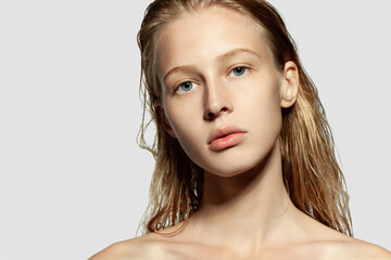 Young blond girl headshot beauty studio portrait on copy space. Model with naked shoulders, wet...