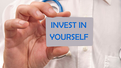 invest in yourself the text on the card in the man's hand